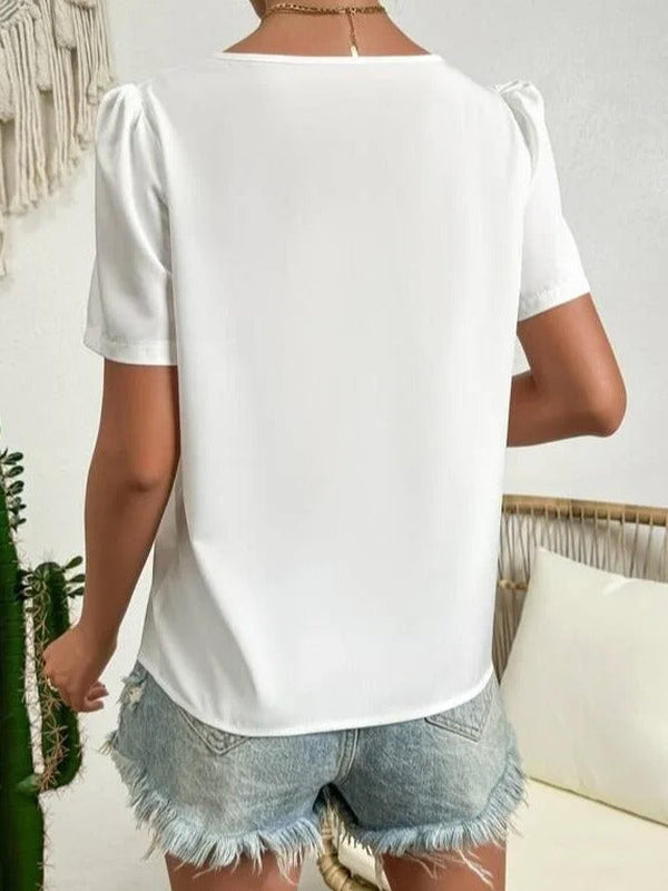 Blouse blanche asymétrique avec manches bouffantes et col