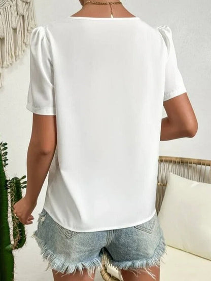 Blouse blanche asymétrique avec manches bouffantes et col